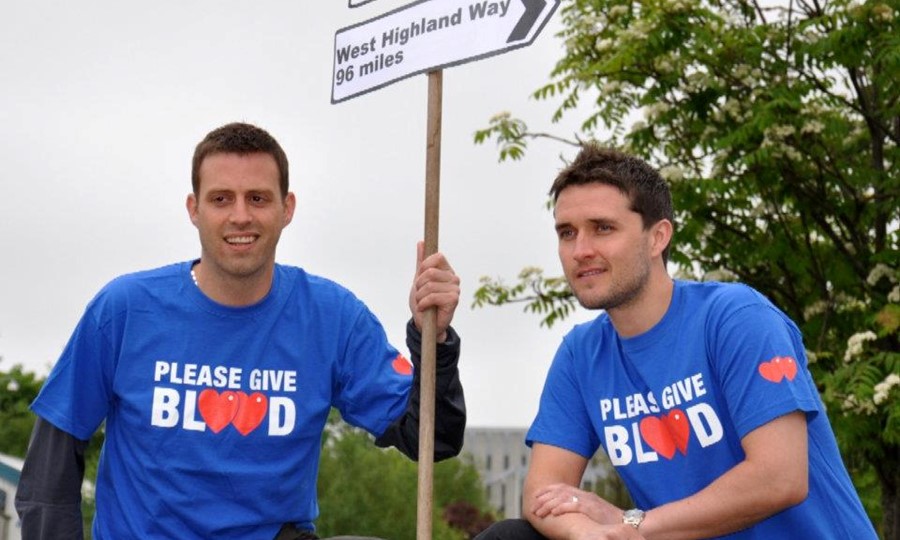 Grant and his friend wear Give Blood t-shirts at the beginning of the West Highland Way