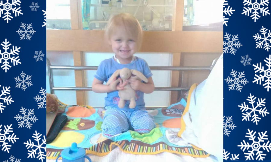 Amelia aged three, in hospital, cuddling a toy rabbit.
