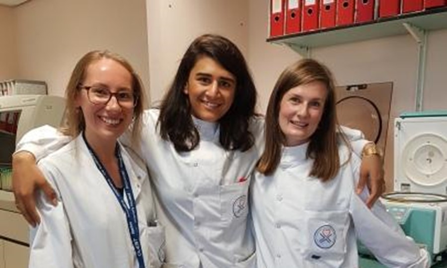 Biomedical staff from Glasgow smile and pose for a photo in lab coats. 