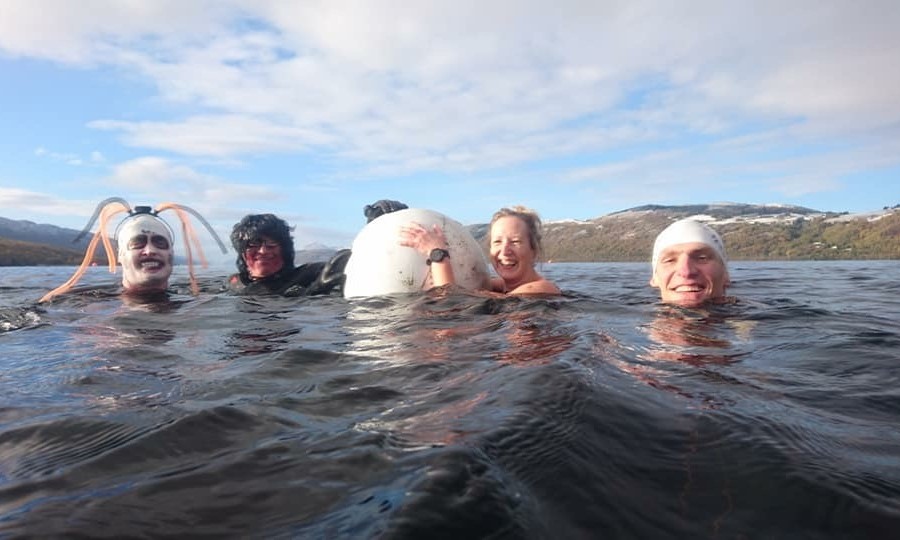 Four swimmers hold on to float while in swimming in Loch Ness. 