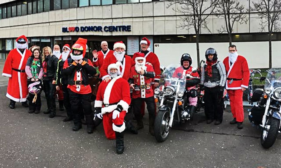 Members of Dingly's Motorcycle Club stand outside Edinburgh Blood Donor Centre wearing Santa Claus outfits.