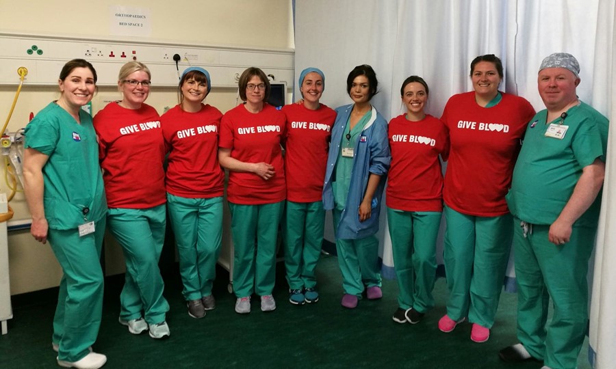 Group photo of the Edinburgh Royal Infirmary team dressed in scrubs and Give Blood t-shirts. 