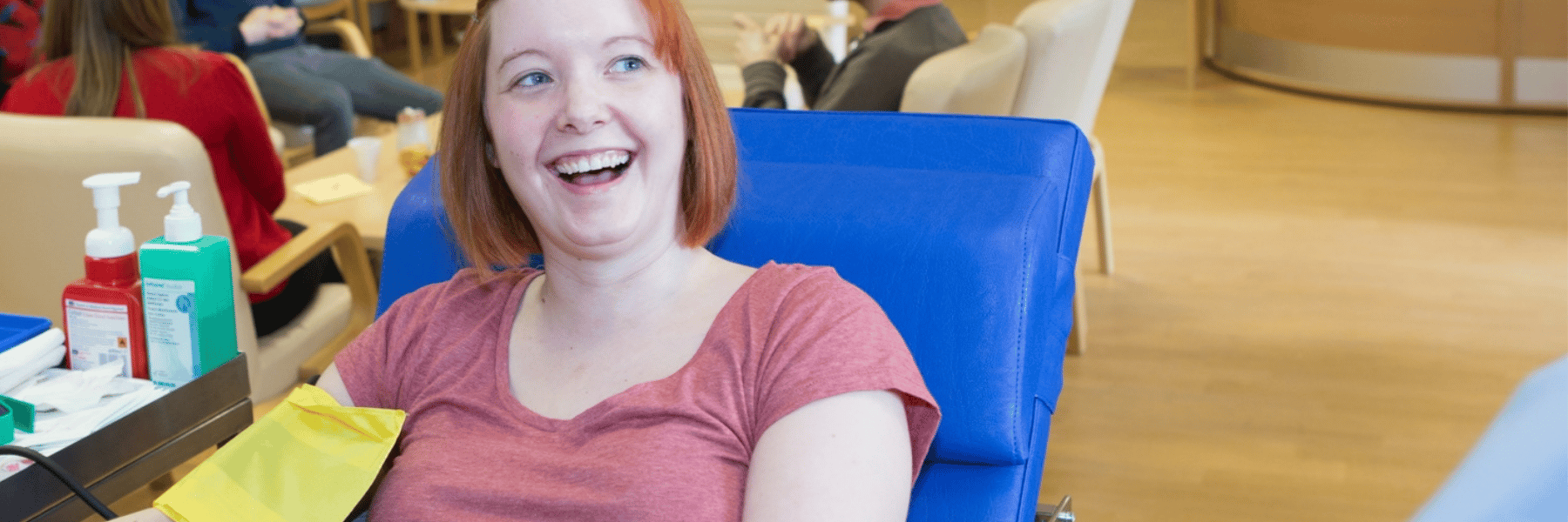 Girl smioles and gives blood at Dundee Donor Centre