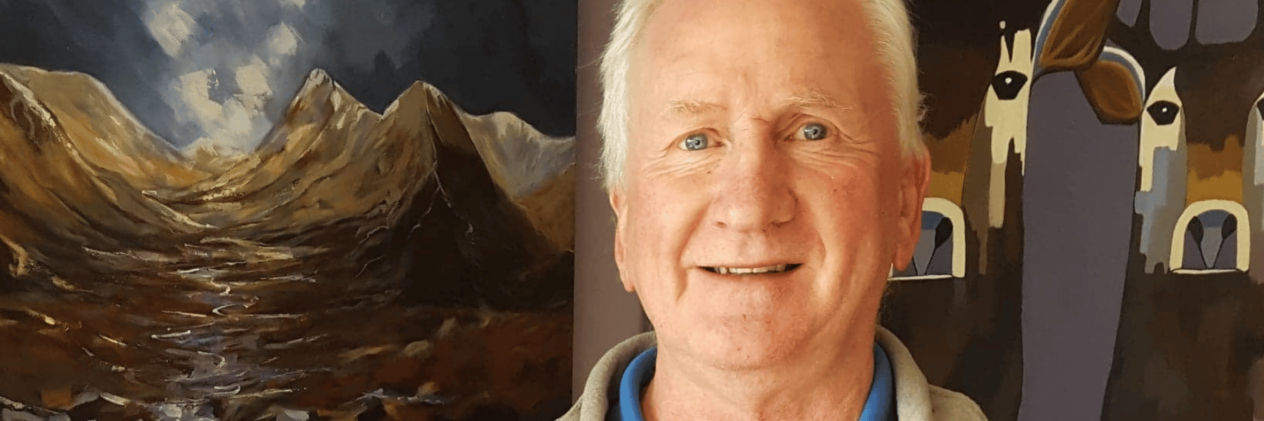 Graham, an older man with white hair, stands in front of a painting.