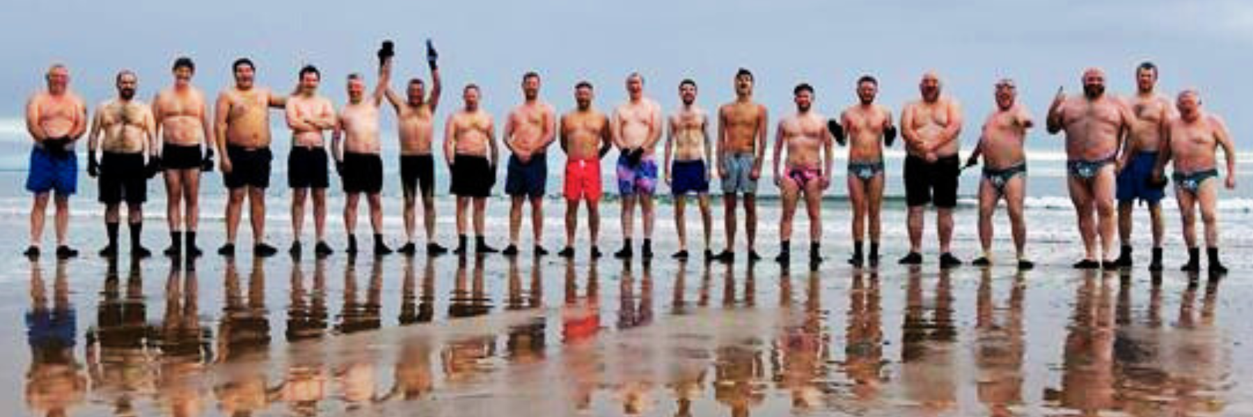 20 of the Baltic boys in a line on Aberdeen beach, wearing swimming costumes.