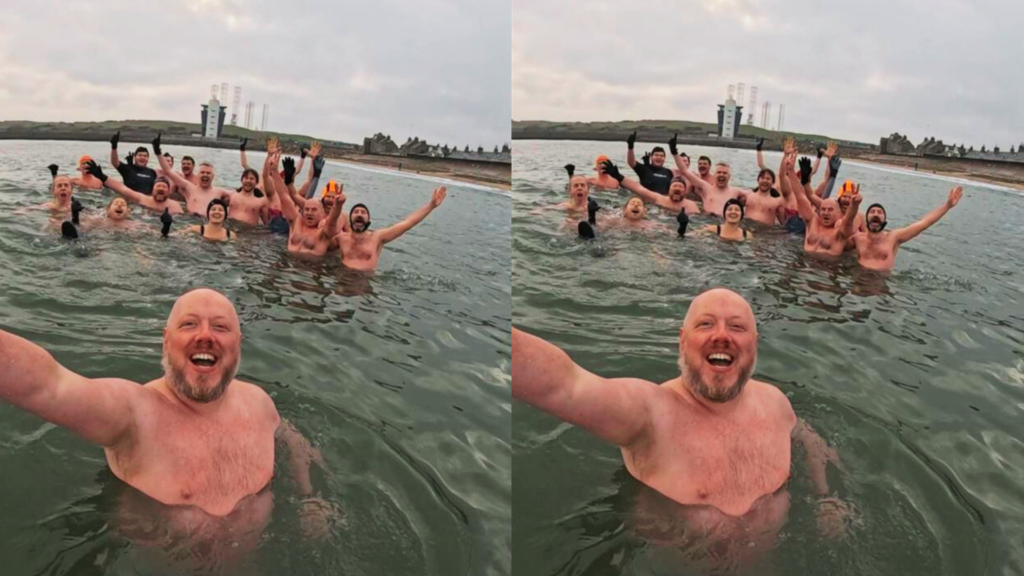 16 of the Baltic Boys swimming in the sea - picture is a selfie, all men smiling